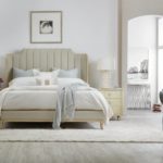 Picture of a bed with a tufted fabric headboard.